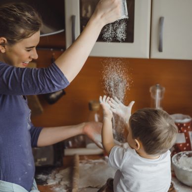 little boy in the kitchen helps mom to cook. the child is involved in cooking.